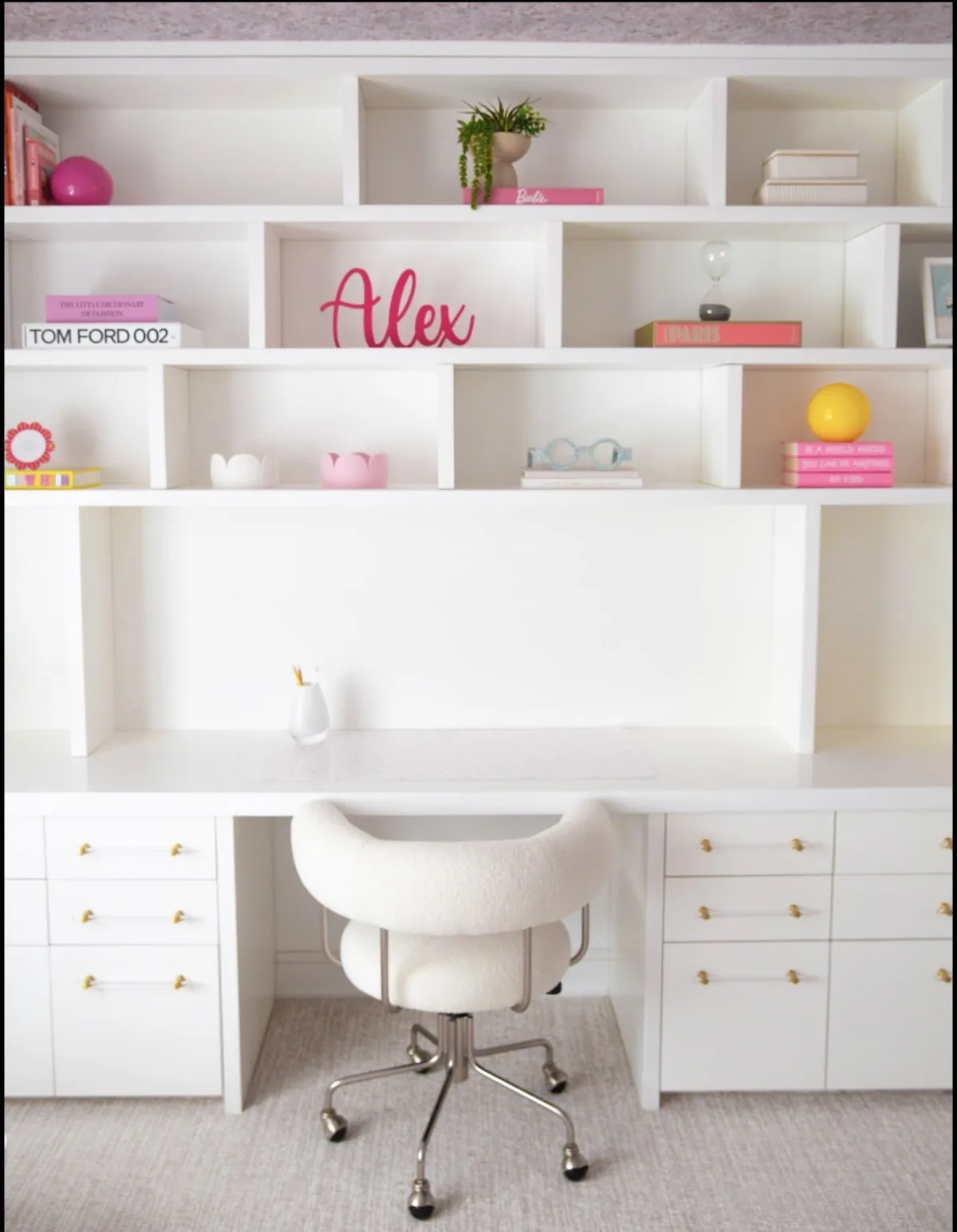 White built-in desk and shelves with pink accents in a Short Hills home