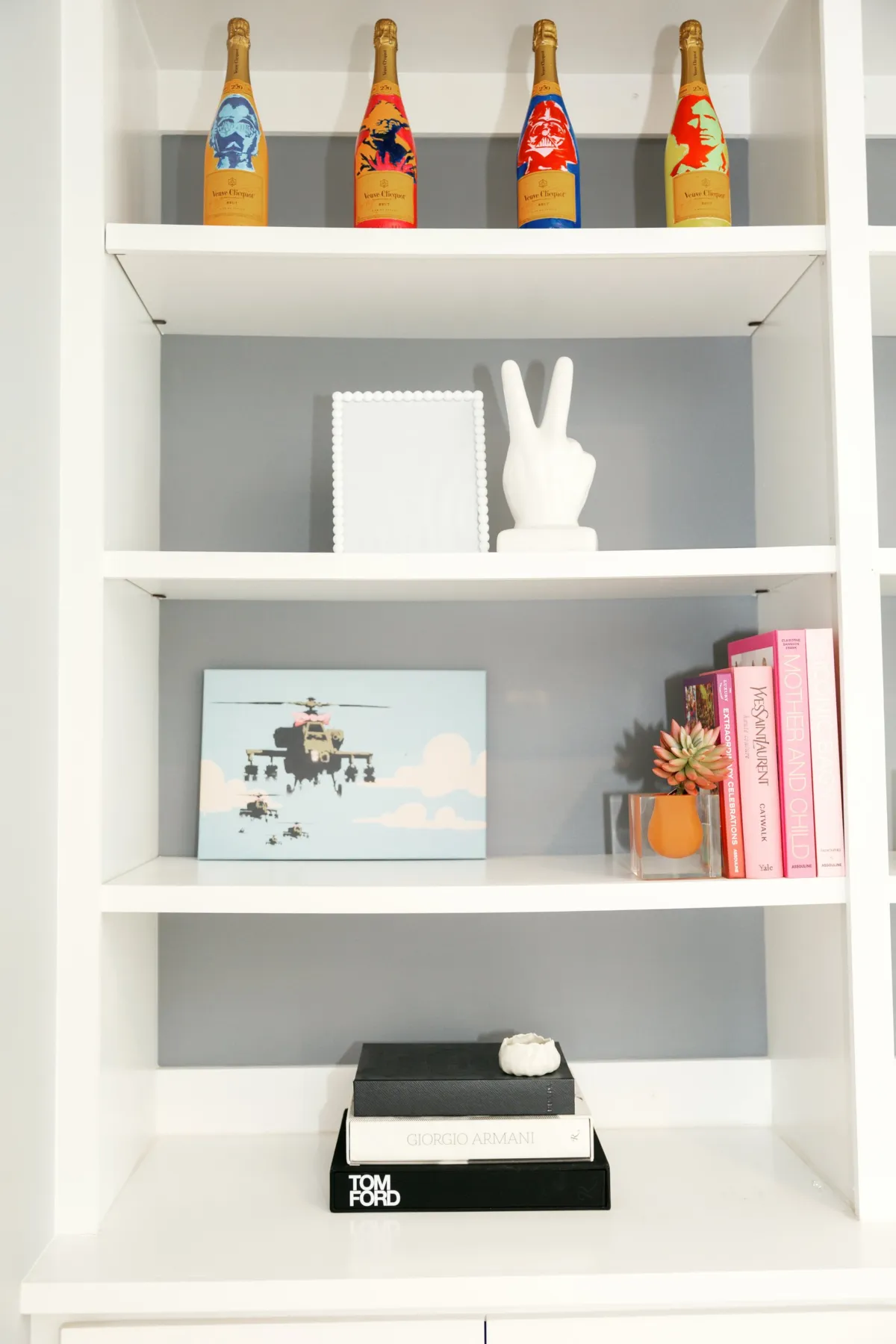 White built-ins styled with champagne bottles, art, books and objects