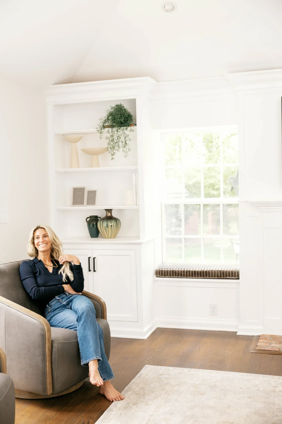 Marisa seated beside the styled shelves and window seat