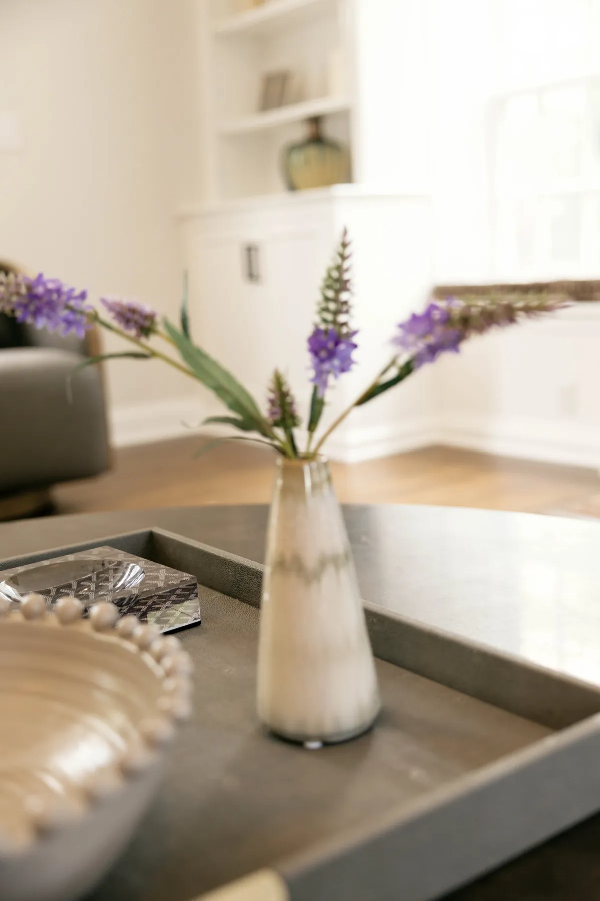 Detail of purple flowers and white bowl on the coffee table