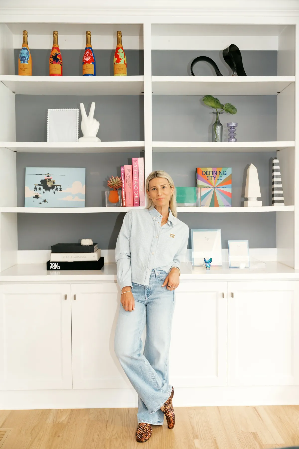 Marisa Sobol standing in front of colorful built-in shelves she styled